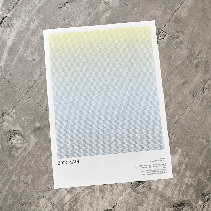 A Birdman or movie script poster laid flat on a textured floor surface.