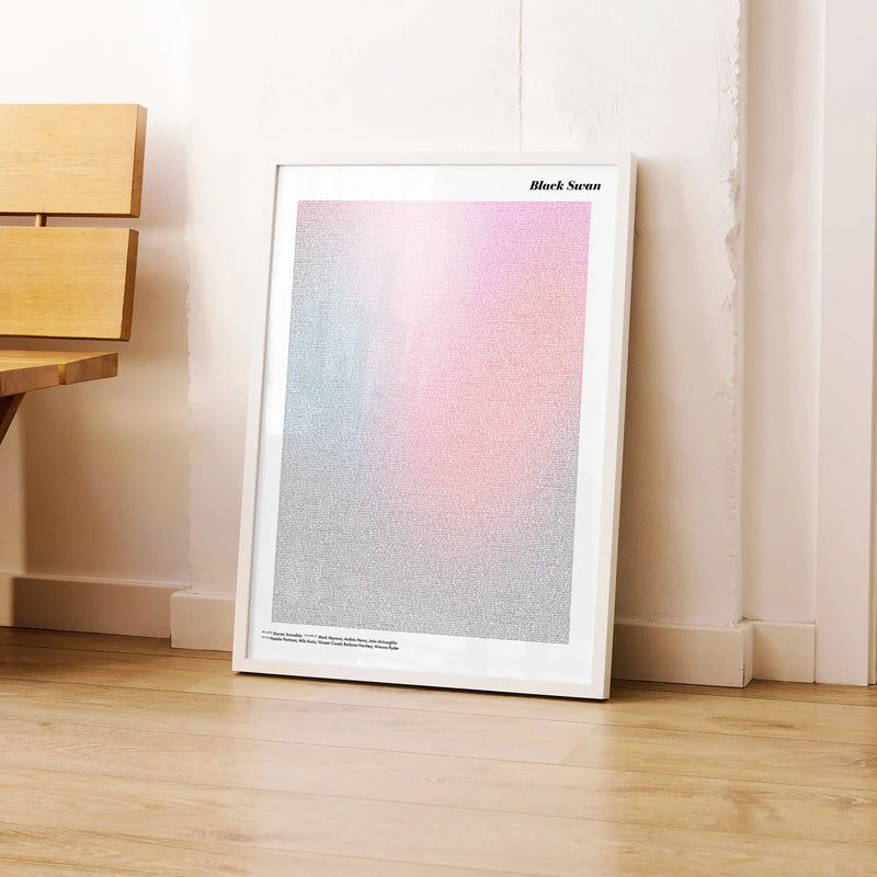 A framed Black Swan movie script poster leaning against a wall in a modern interior.