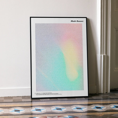 A framed Blade Runner movie script poster leaning against a wall in a minimalist interior.