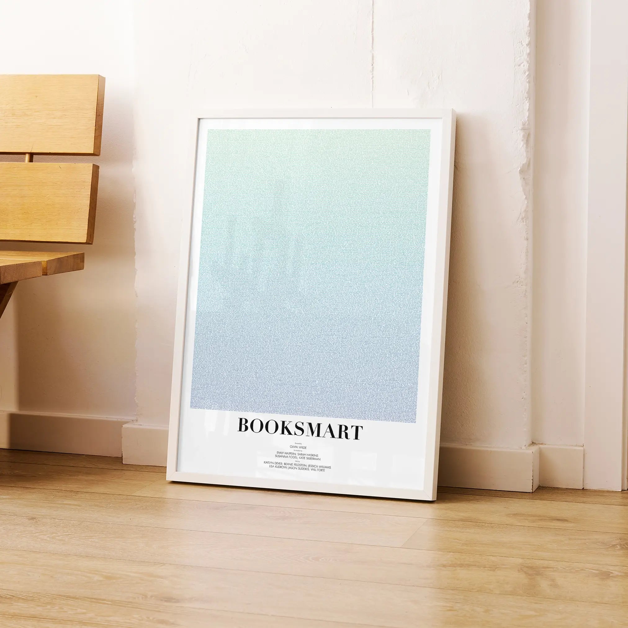 A framed Booksmart movie script poster leaning against a wall in a modern interior.