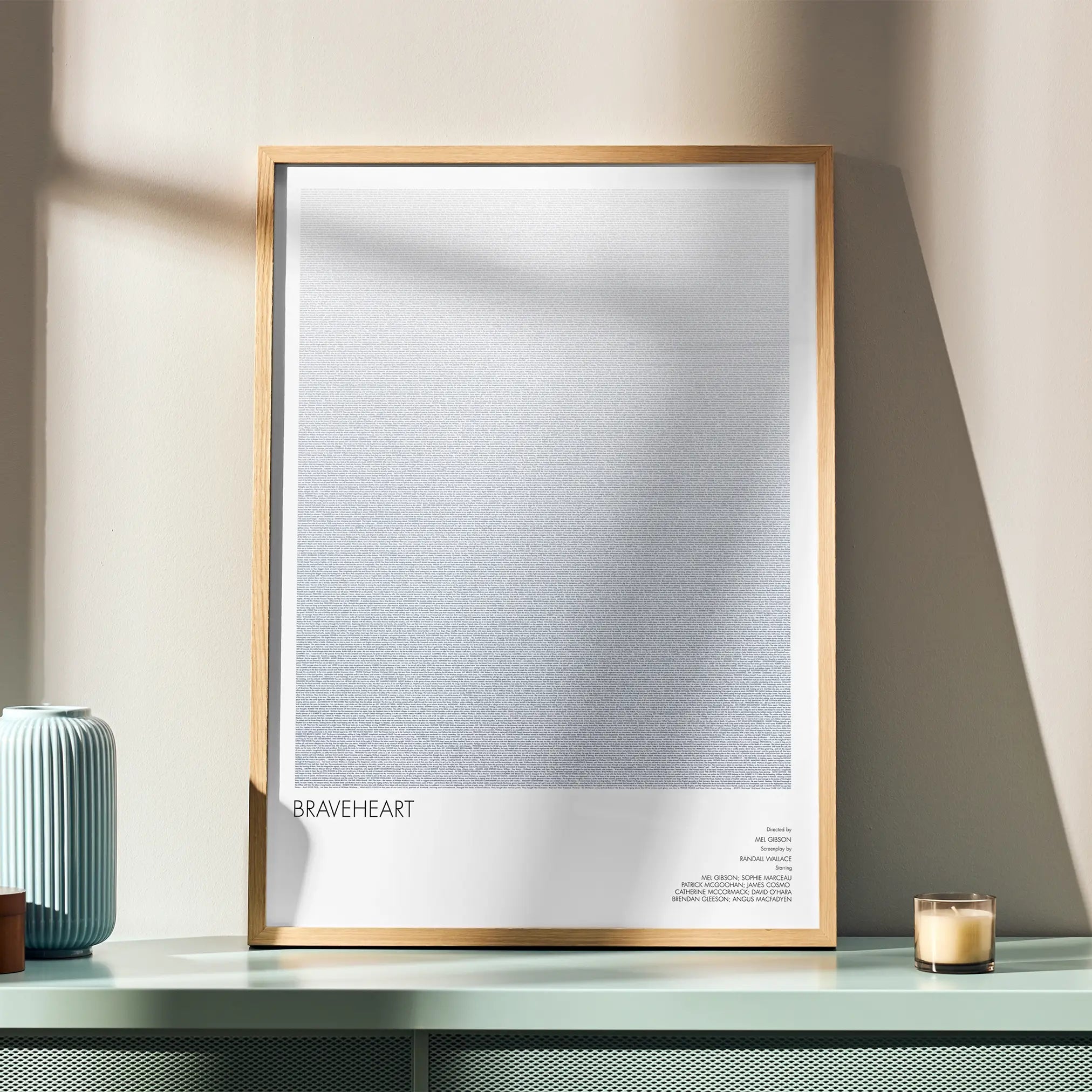 A framed Braveheart movie script poster displayed in a simple modern interior.