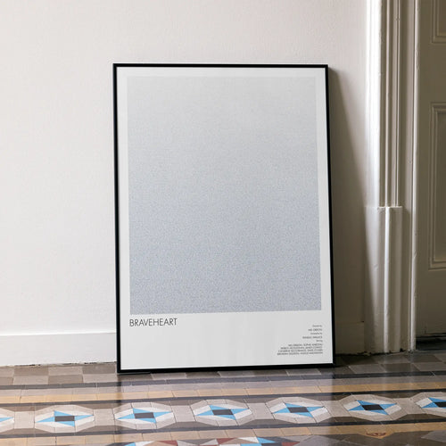 A framed Braveheart movie script poster leaning against a wall in a minimalist interior.