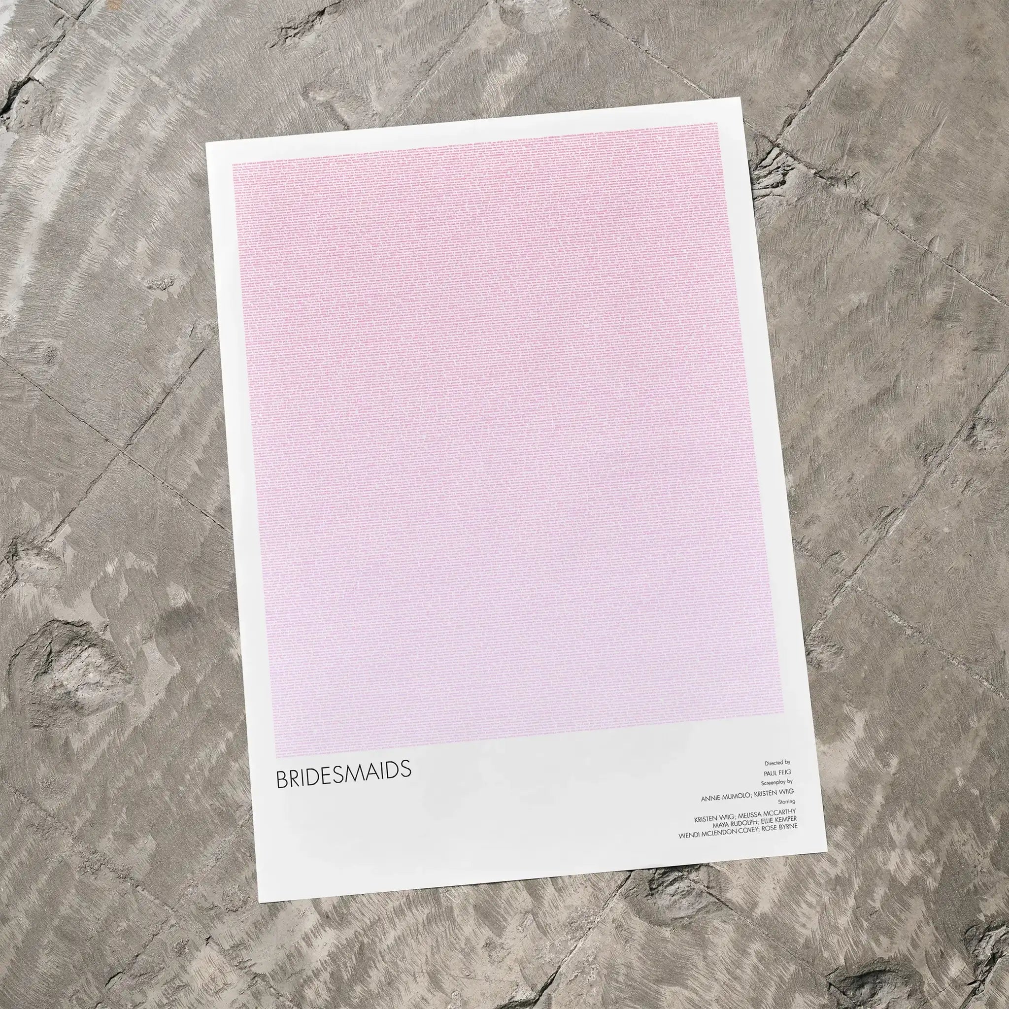 A Bridesmaids movie script poster laid flat on a textured floor surface.