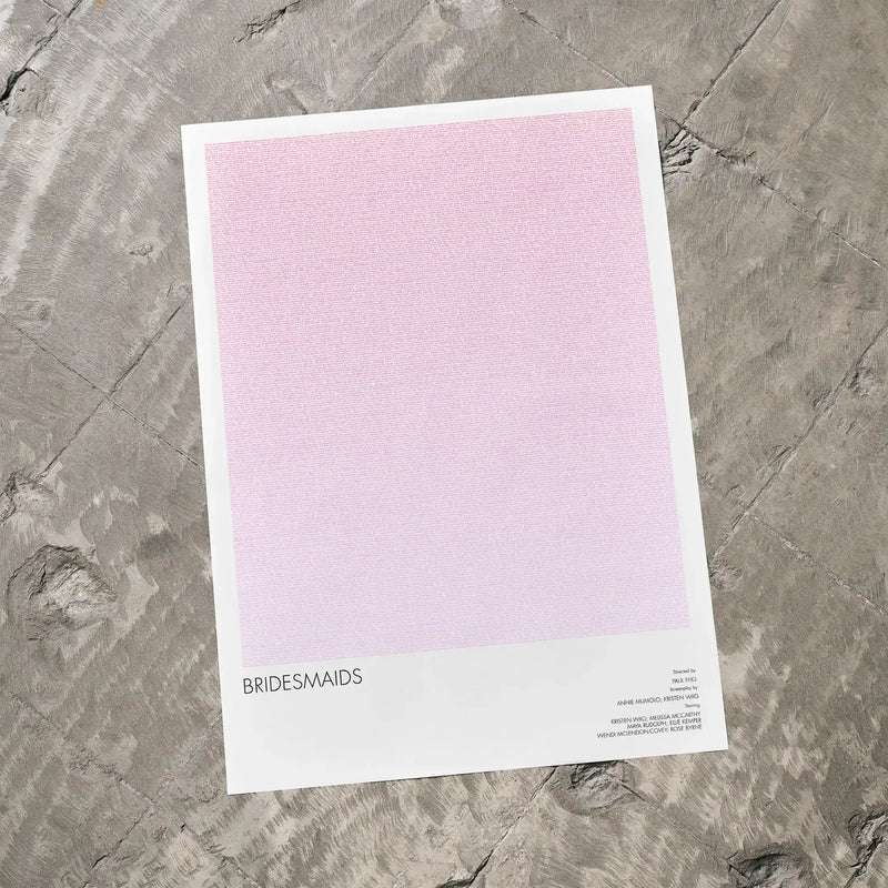 A Bridesmaids movie script poster laid flat on a textured floor surface.