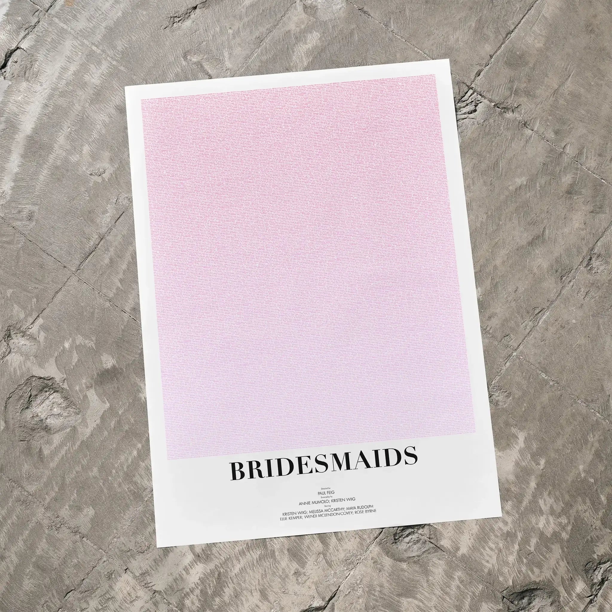 A Bridesmaids movie script poster laid flat on a textured floor surface.