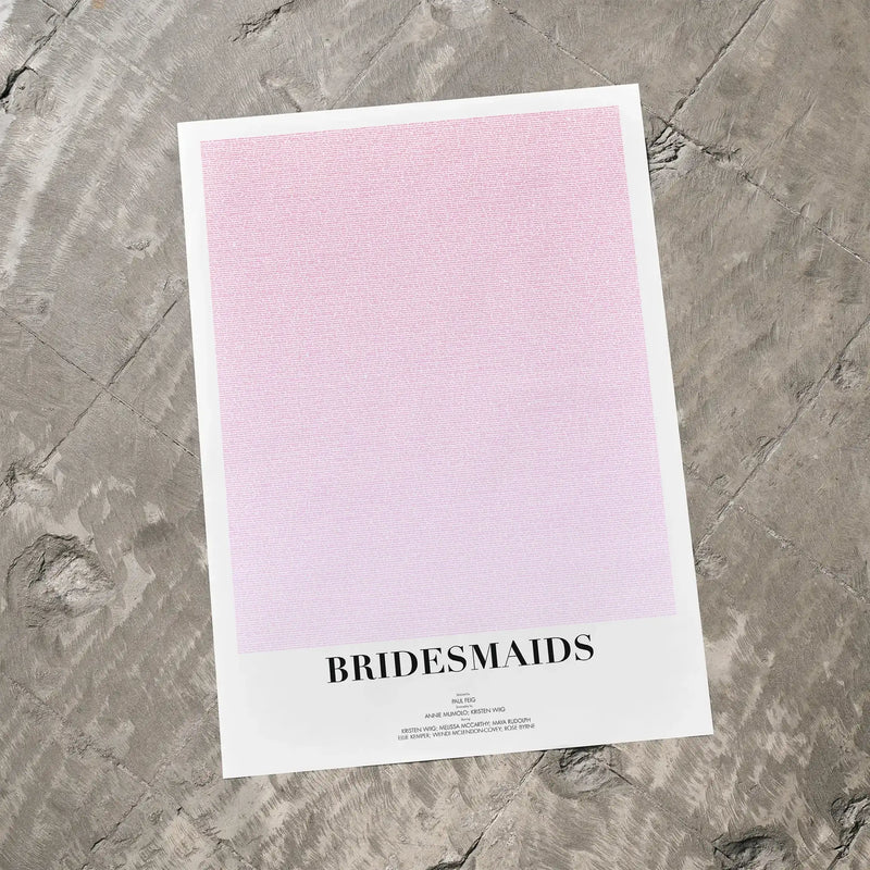 A Bridesmaids movie script poster laid flat on a textured floor surface.