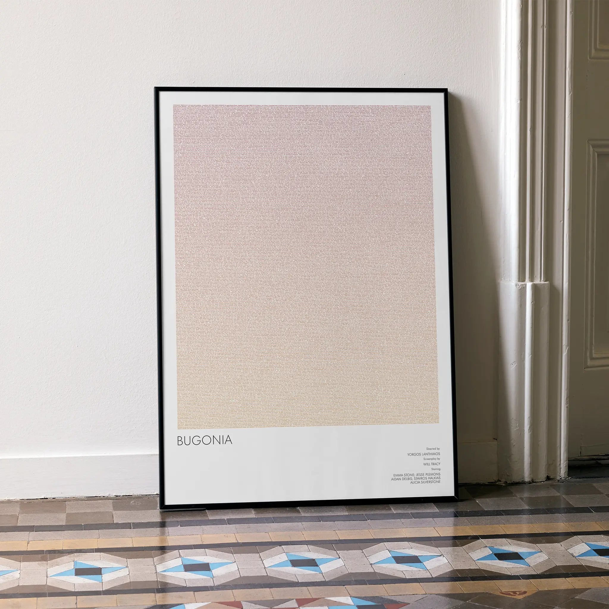 A framed Bugonia movie script poster leaning against a wall in a minimalist interior.