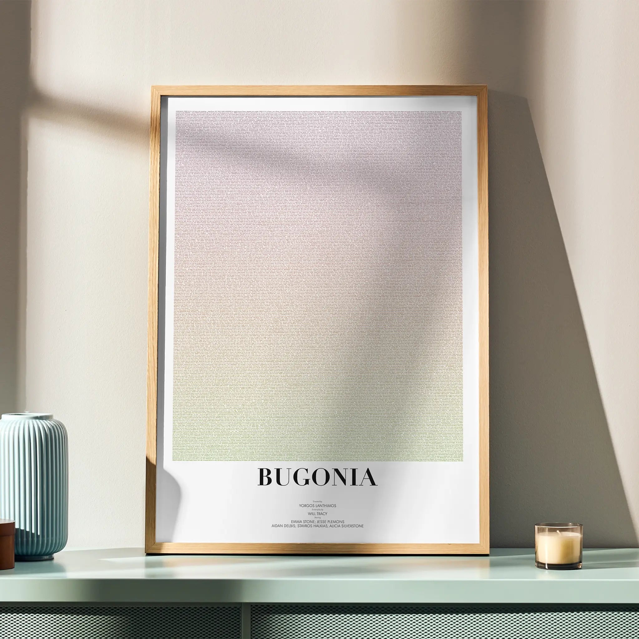 A framed Bugonia movie script poster displayed in a simple modern interior.
