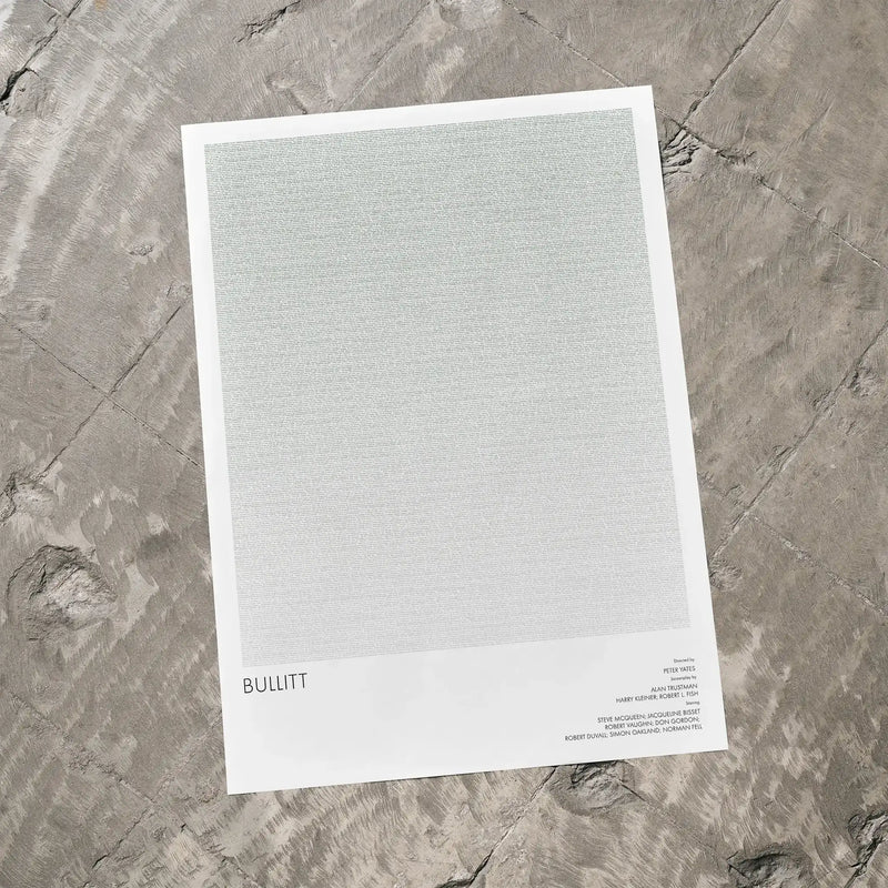 A Bullitt movie script poster laid flat on a textured floor surface.