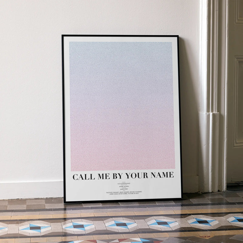 A framed Call Me by Your Name movie script poster leaning against a wall in a minimalist interior.