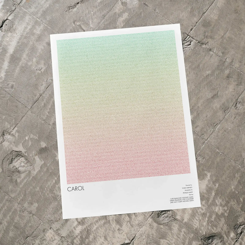 A Carol movie script poster laid flat on a textured floor surface.