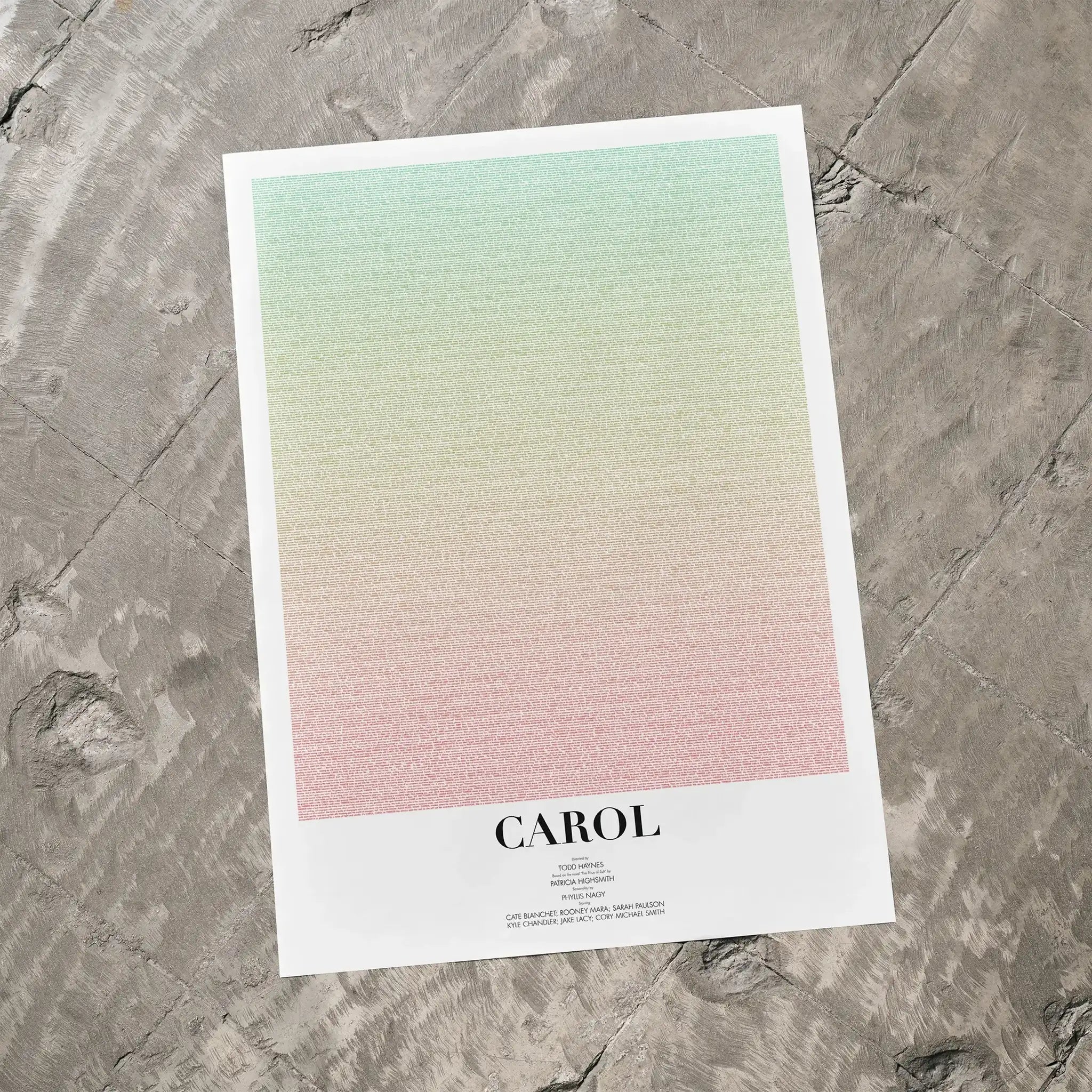 A Carol movie script poster laid flat on a textured floor surface.
