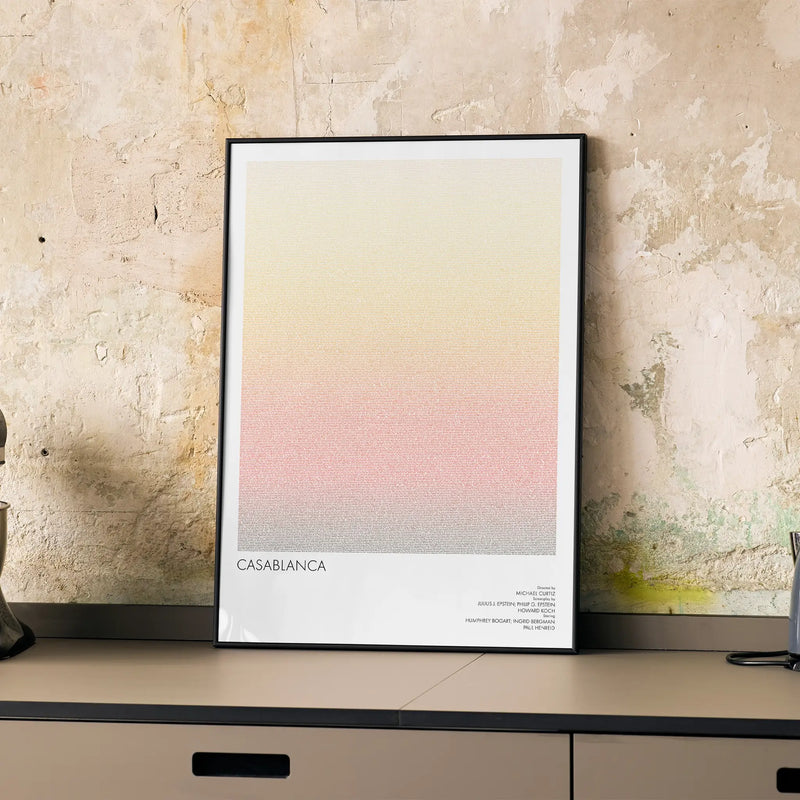 A framed Casablanca movie script poster displayed on a cabinet in a minimalist interior.