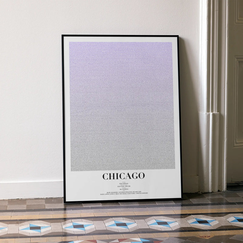 A framed Chicago movie script poster leaning against a wall in a minimalist interior.