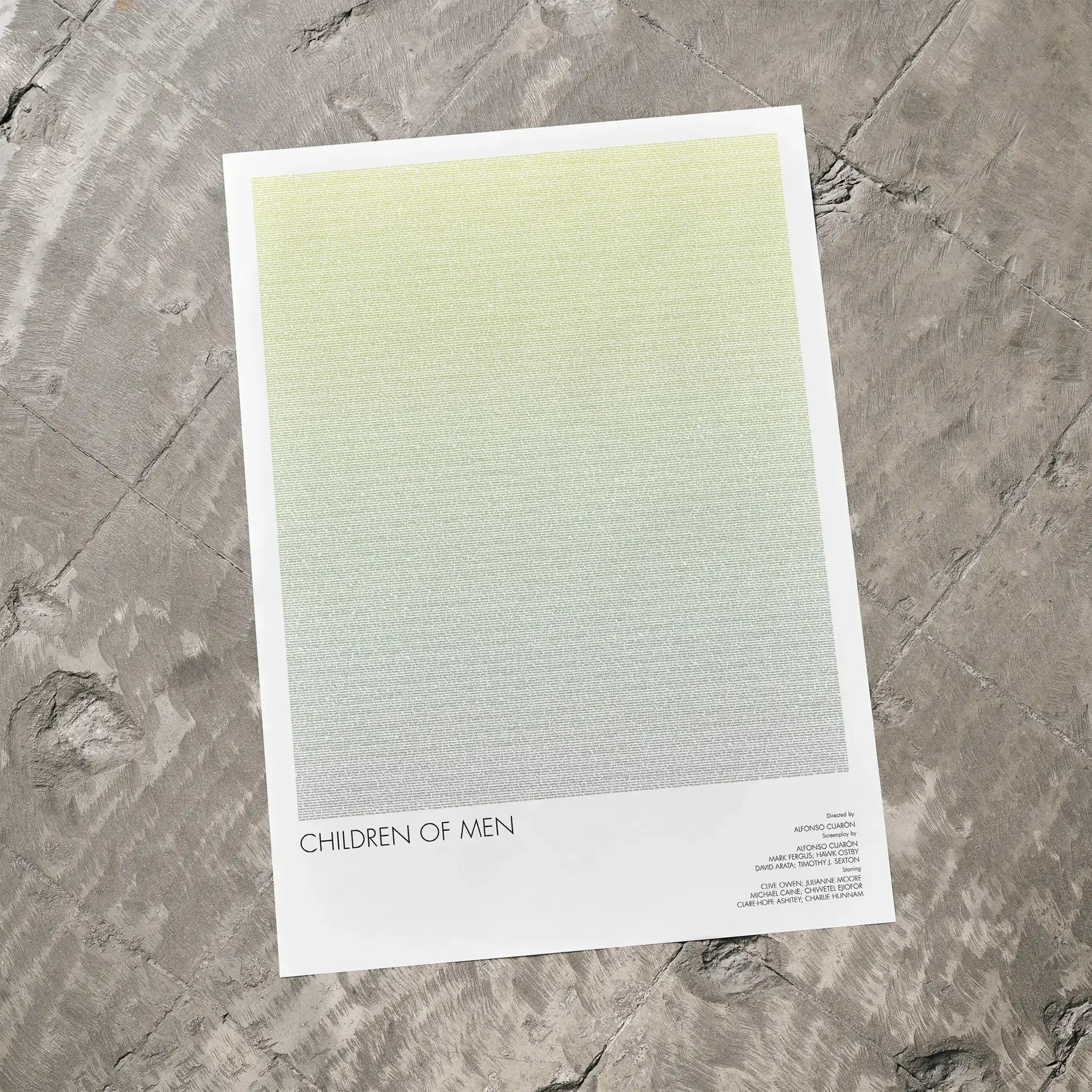 A Children of Men movie script poster laid flat on a textured floor surface.