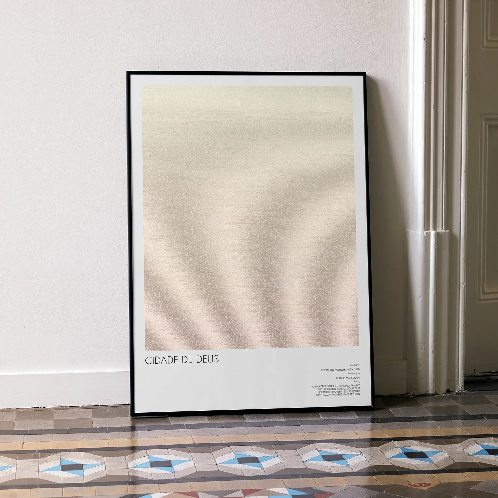 A framed Cidade de Deus movie script poster leaning against a wall in a minimalist interior.
