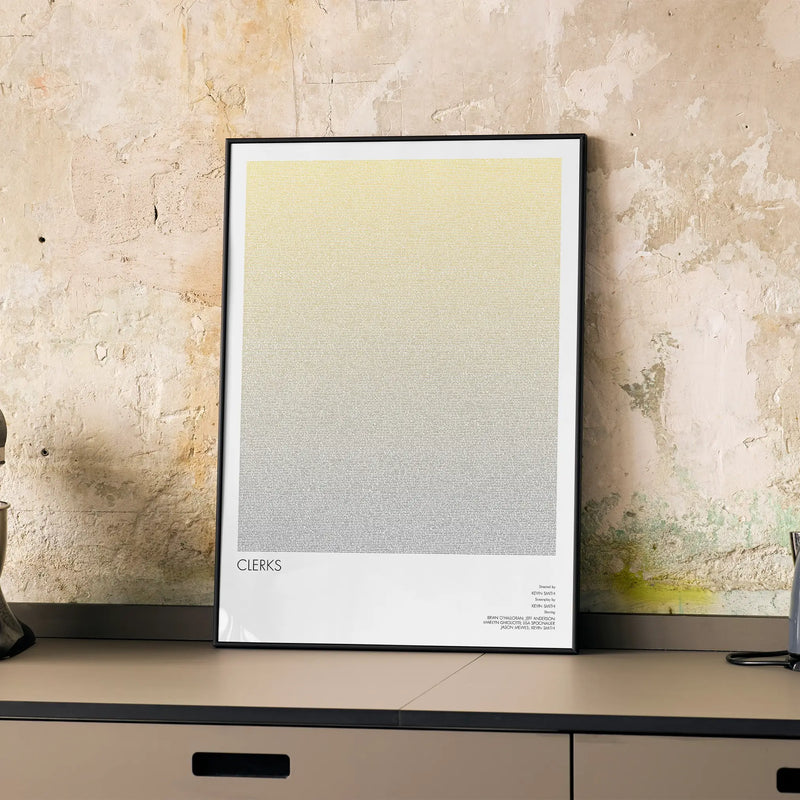 A framed Clerks movie script poster displayed on a cabinet in a minimalist interior.