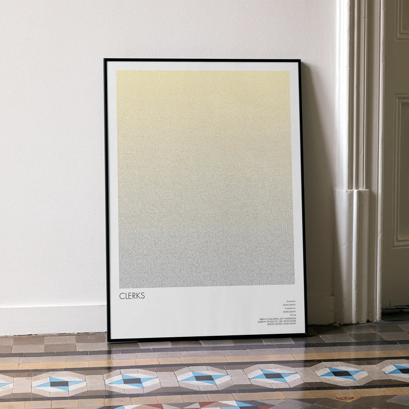 A framed Clerks movie script poster leaning against a wall in a minimalist interior.