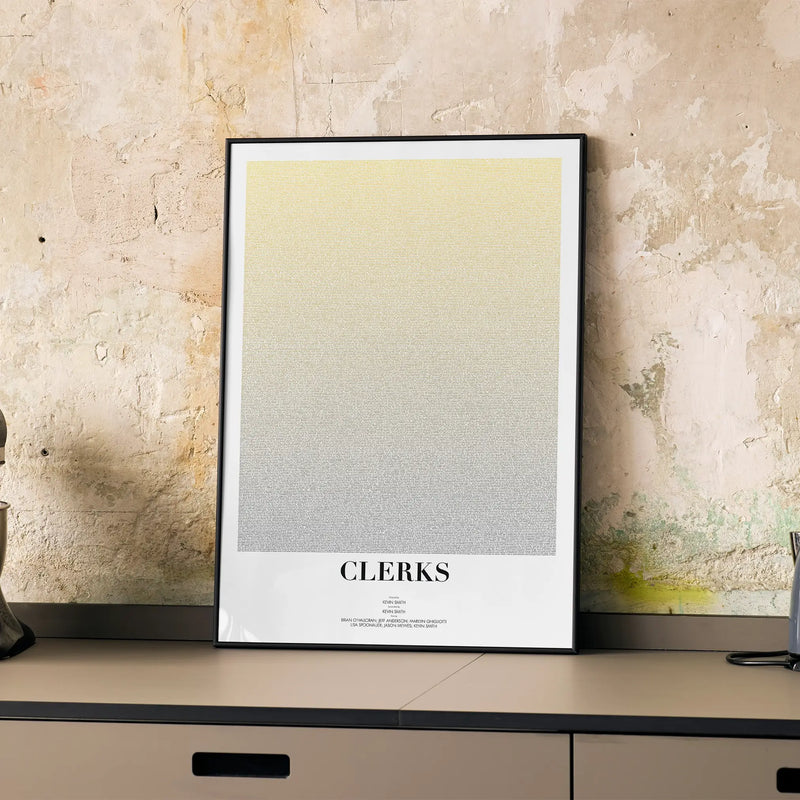 A framed Clerks movie script poster displayed on a cabinet in a minimalist interior.