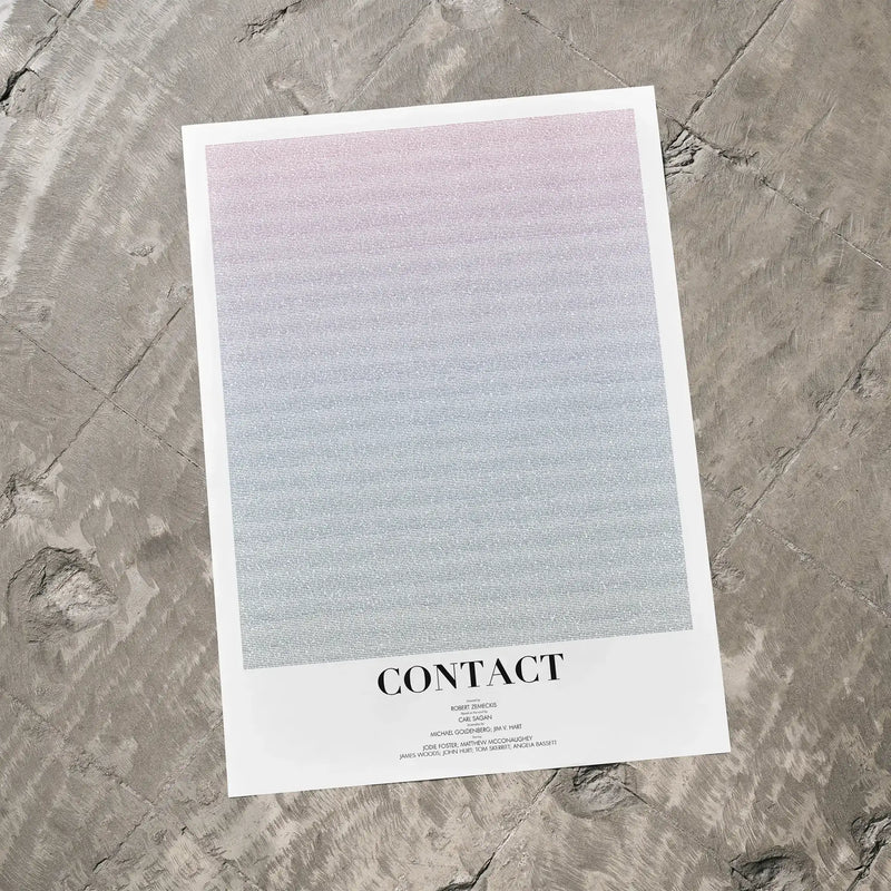 A Contact movie script poster laid flat on a textured floor surface.