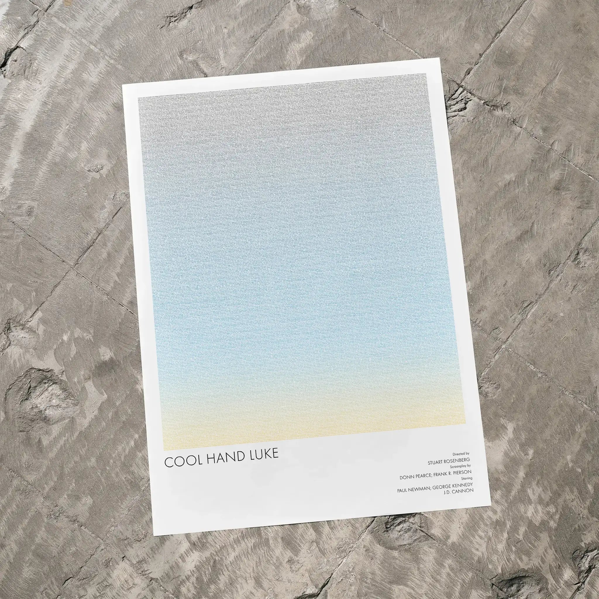 A Cool Hand Luke movie script poster laid flat on a textured floor surface.