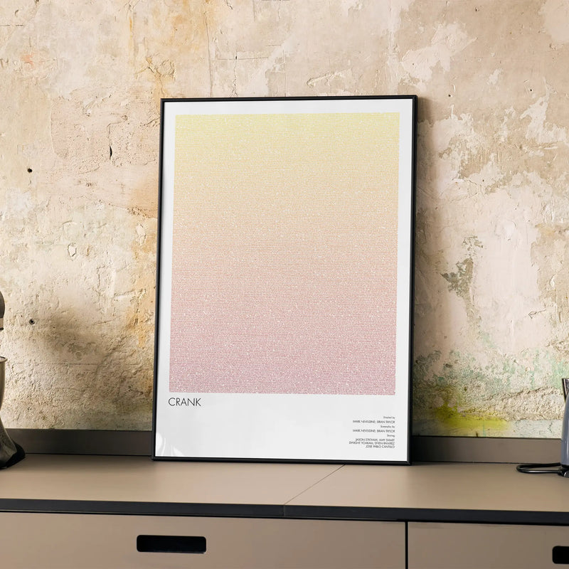 A framed Crank movie script poster displayed on a cabinet in a minimalist interior.