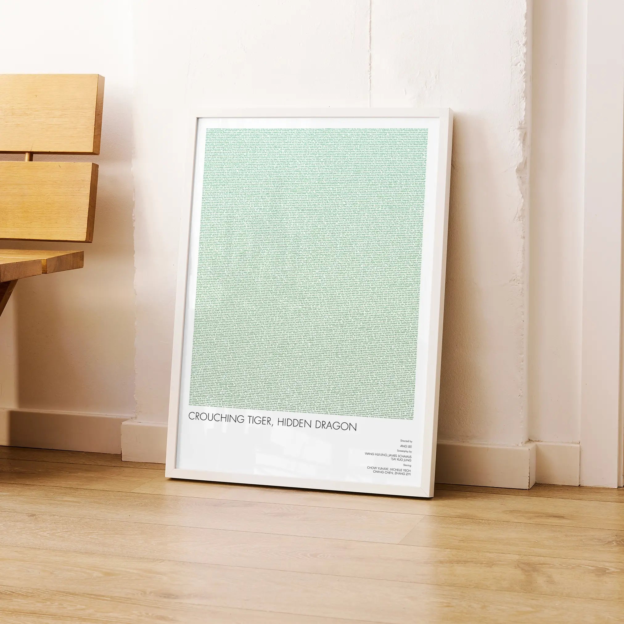A framed Crouching Tiger, Hidden Dragon movie script poster leaning against a wall in a modern interior.