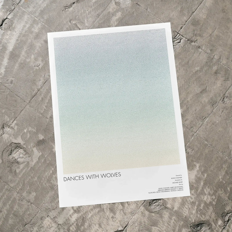 A Dances with Wolves movie script poster laid flat on a textured floor surface.