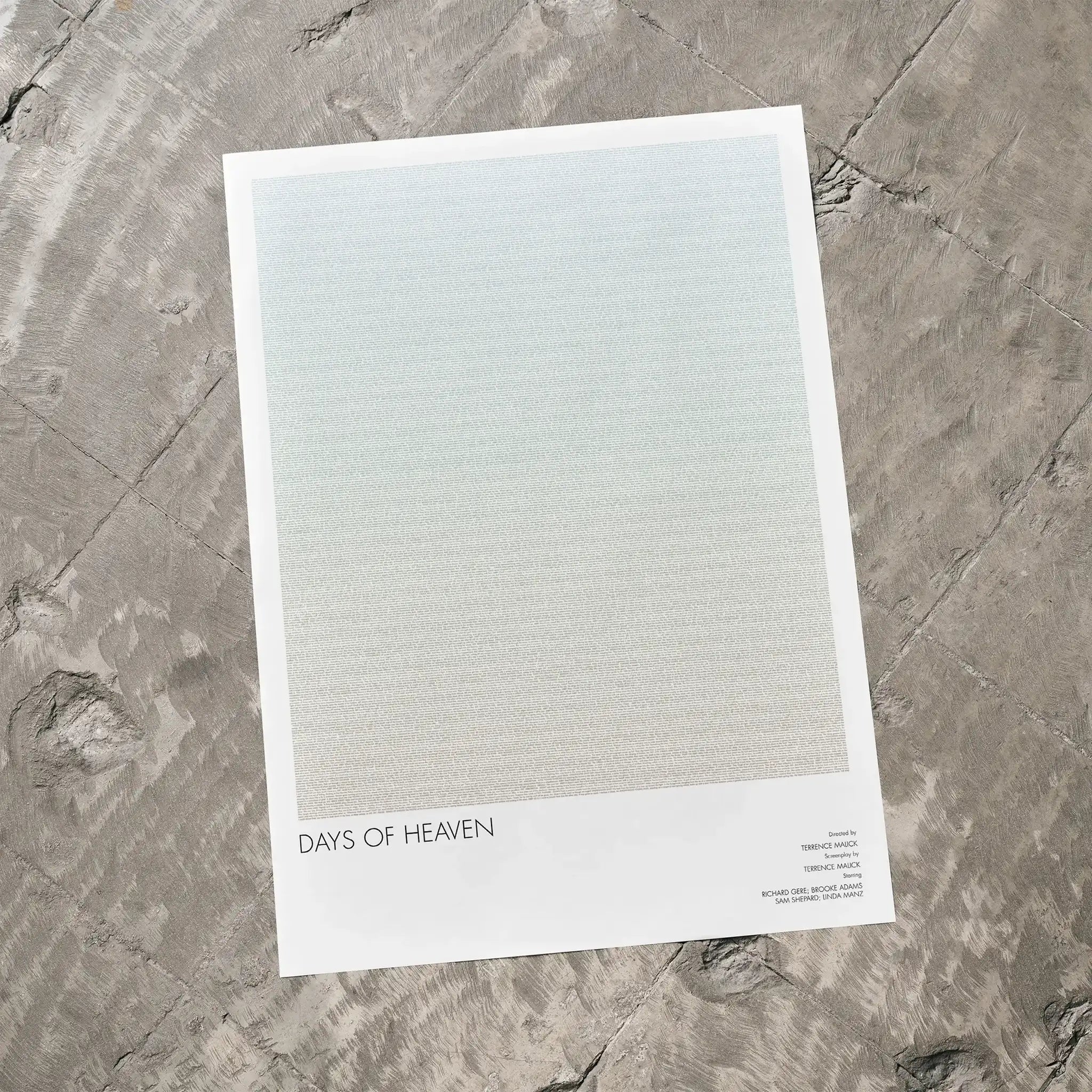 A Days of Heaven movie script poster laid flat on a textured floor surface.