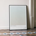 A framed Days of Heaven movie script poster leaning against a wall in a minimalist interior.
