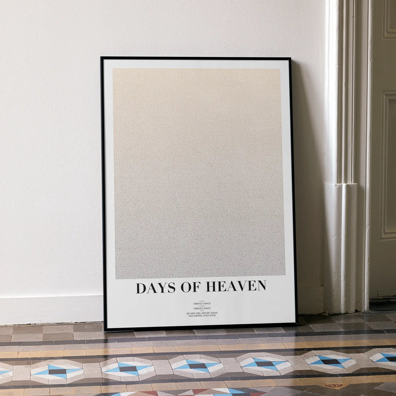 A framed Days of Heaven movie script poster leaning against a wall in a minimalist interior.