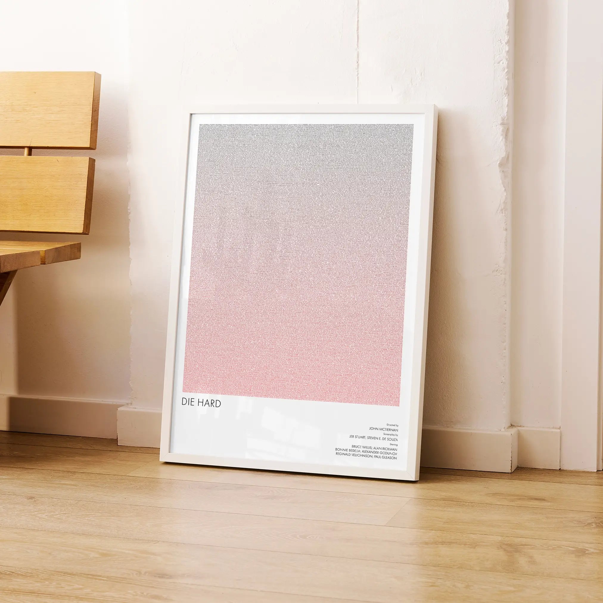A framed Die Hard movie script poster leaning against a wall in a modern interior.