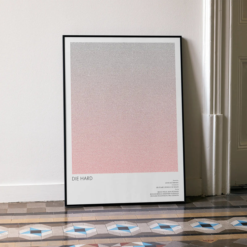 A framed Die Hard movie script poster leaning against a wall in a minimalist interior.