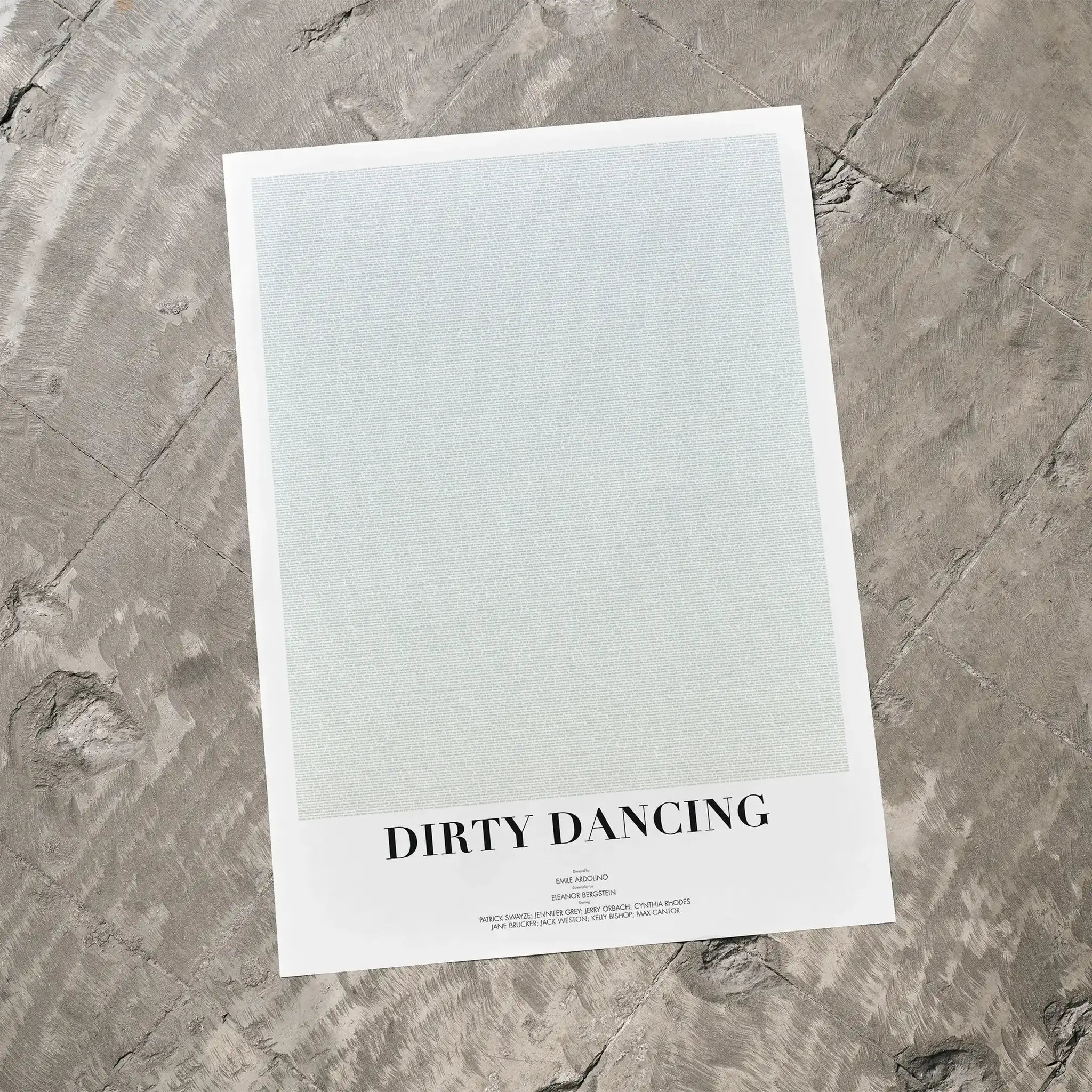A Dirty Dancing movie script poster laid flat on a textured floor surface.