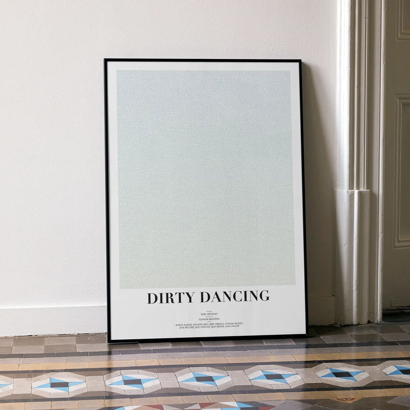 A framed Dirty Dancing movie script poster leaning against a wall in a minimalist interior.