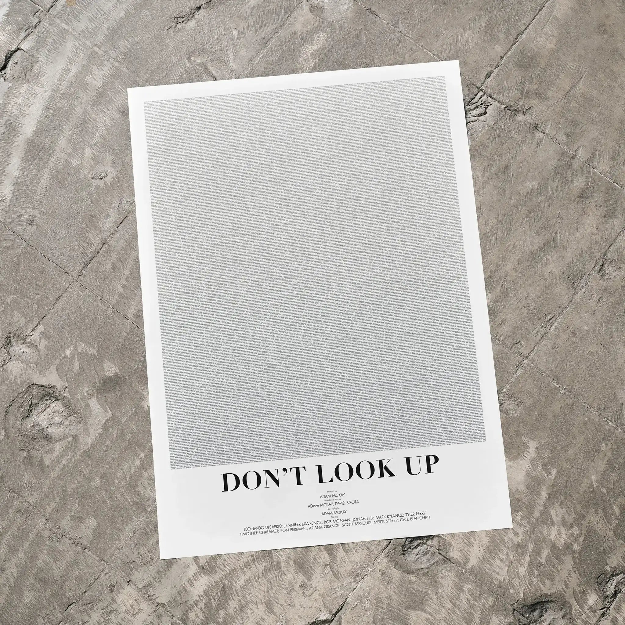 A Don't Look Up movie script poster laid flat on a textured floor surface.