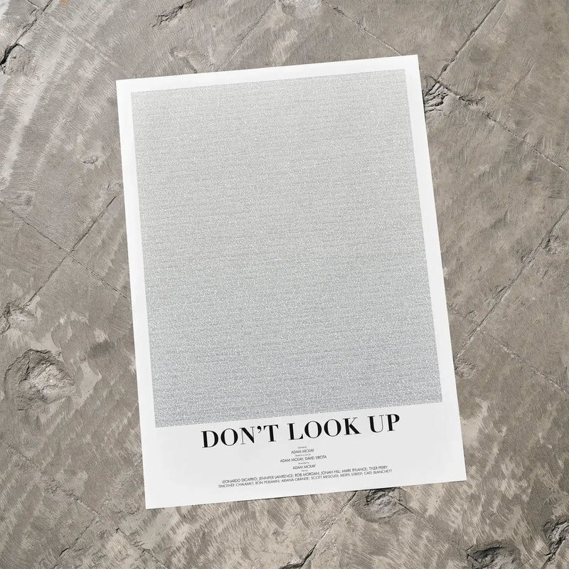 A Don't Look Up movie script poster laid flat on a textured floor surface.