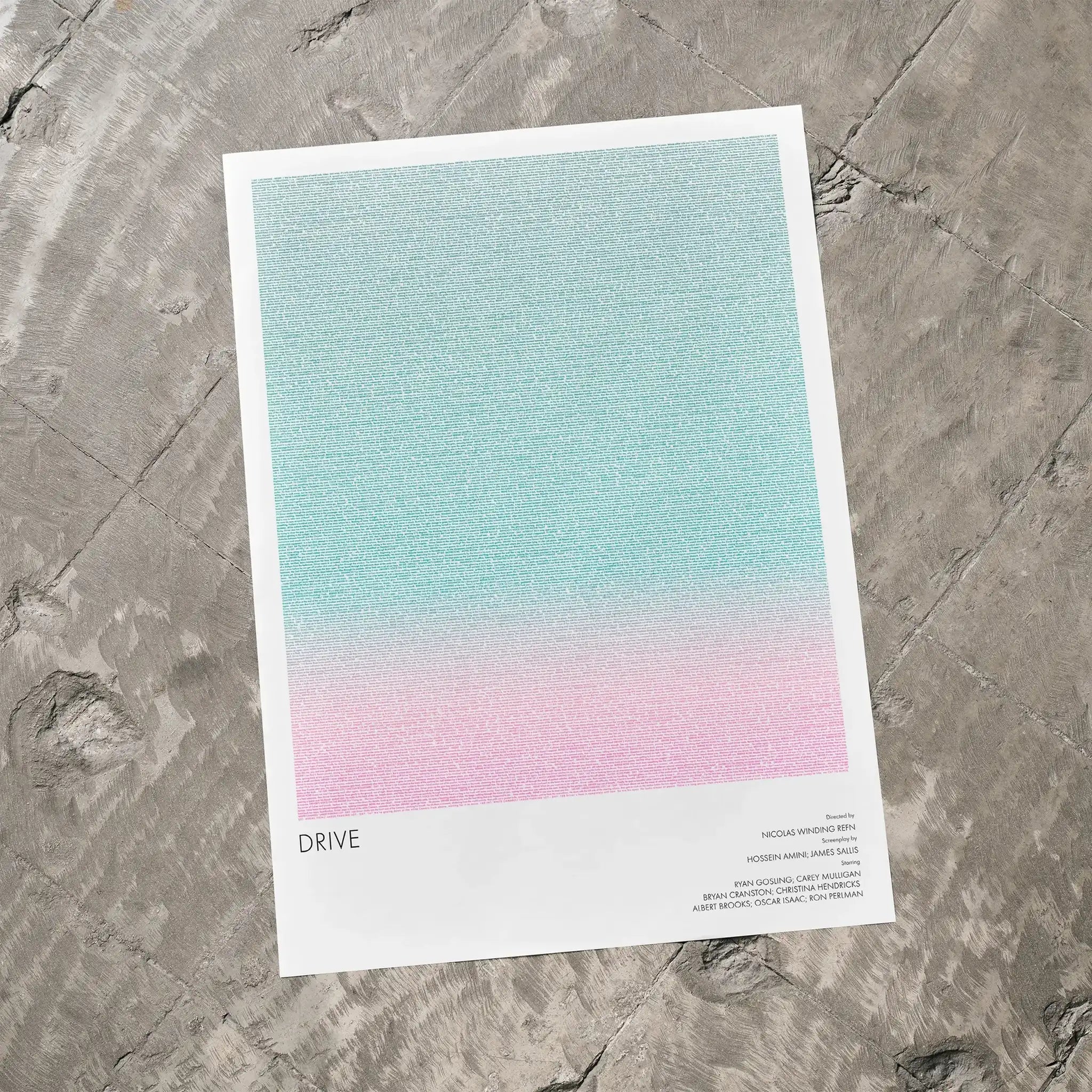 A Drive movie script poster laid flat on a textured floor surface.