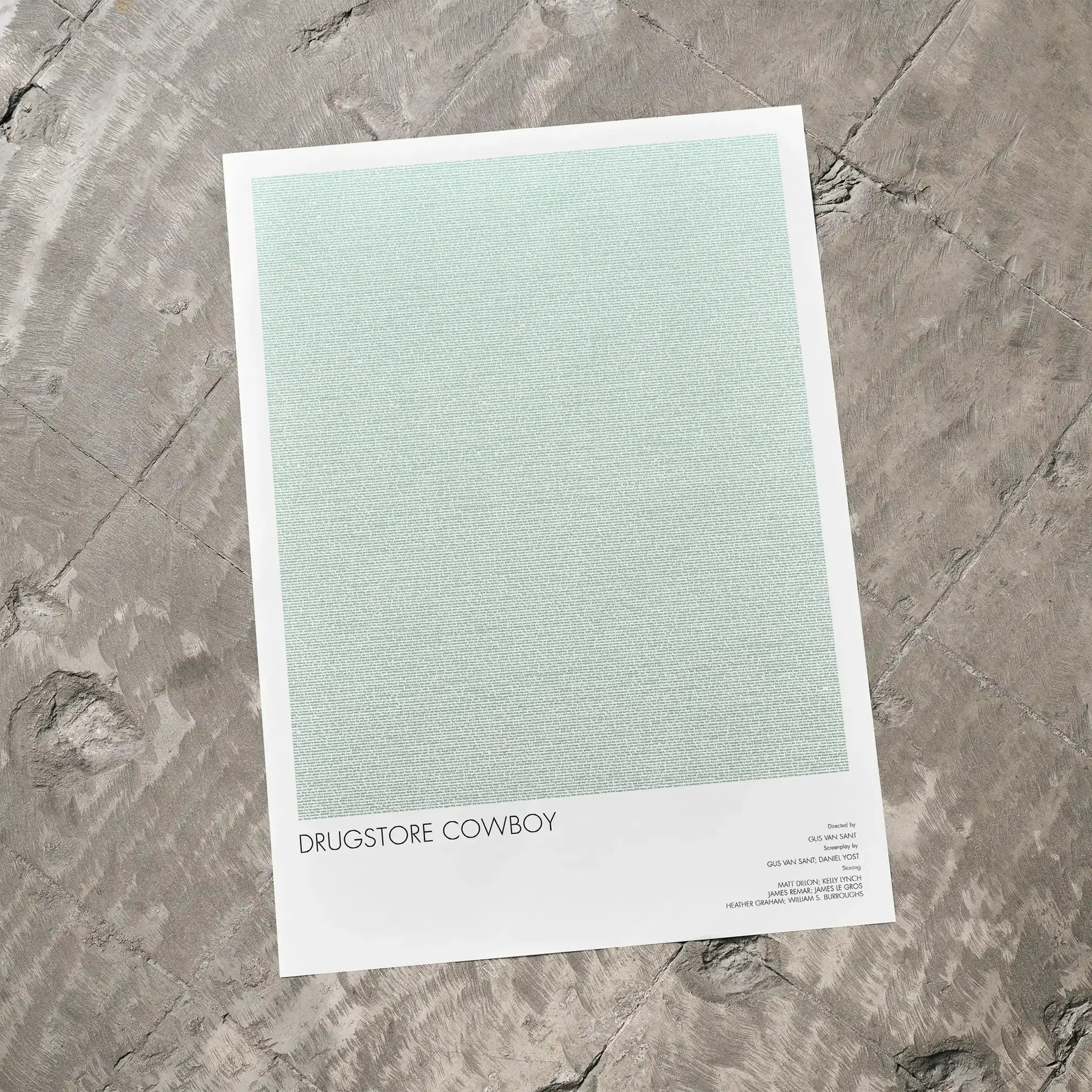 A Drugstore Cowboy movie script poster laid flat on a textured floor surface.