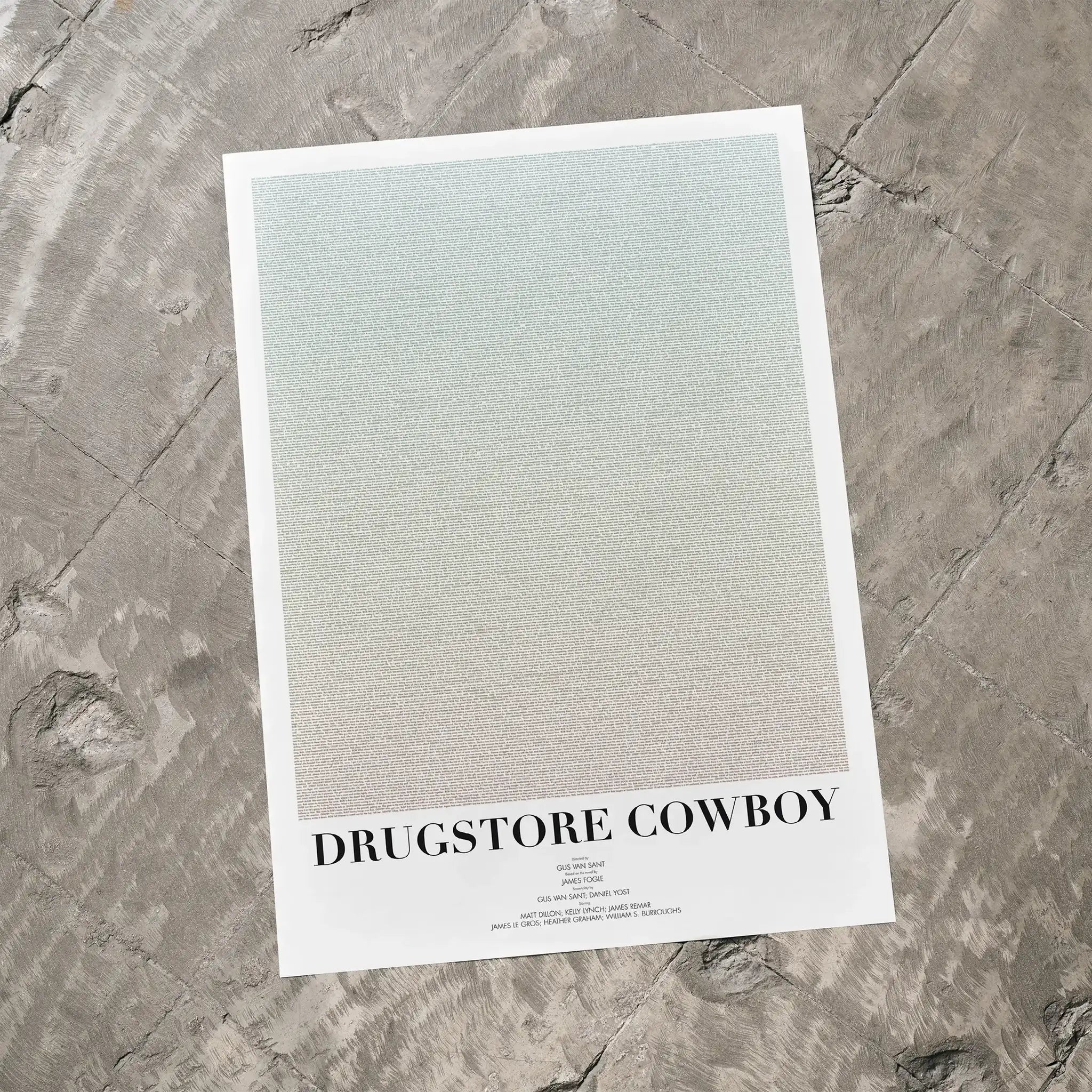 A Drugstore Cowboy movie script poster laid flat on a textured floor surface.
