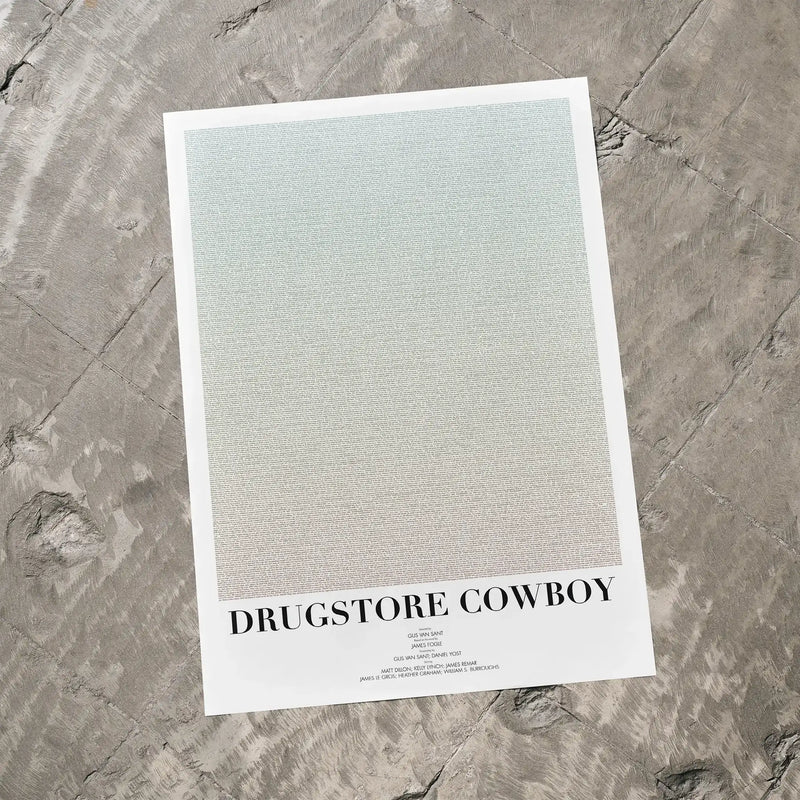 A Drugstore Cowboy movie script poster laid flat on a textured floor surface.