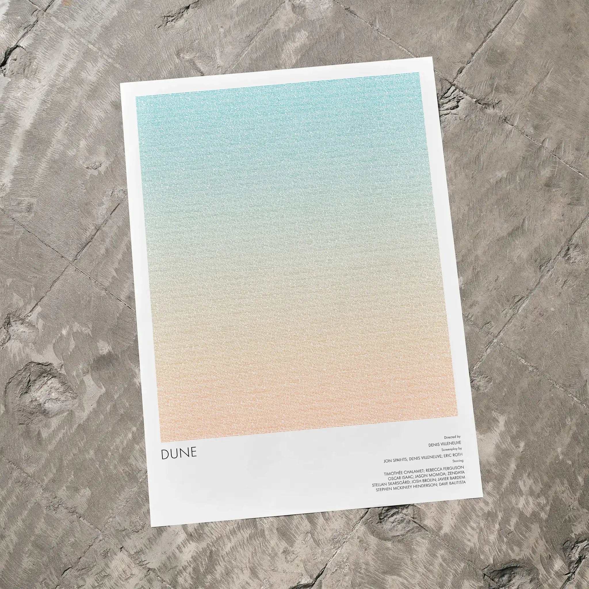 A Dune movie script poster laid flat on a textured floor surface.