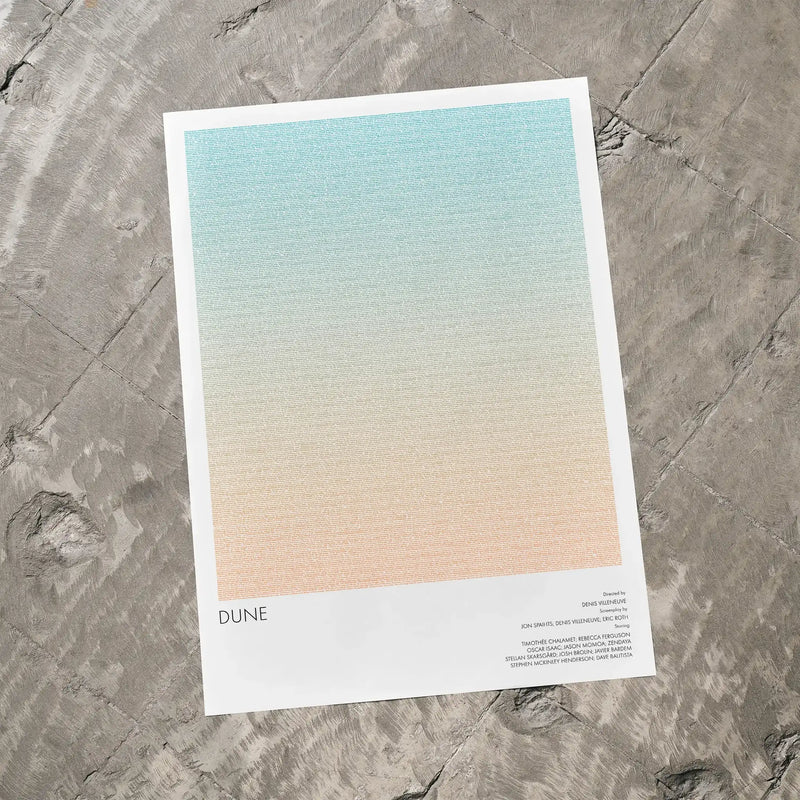 A Dune movie script poster laid flat on a textured floor surface.