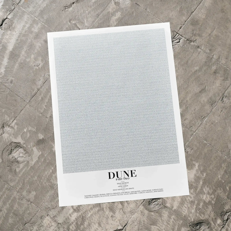 A Dune: Part Two movie script poster laid flat on a textured floor surface.