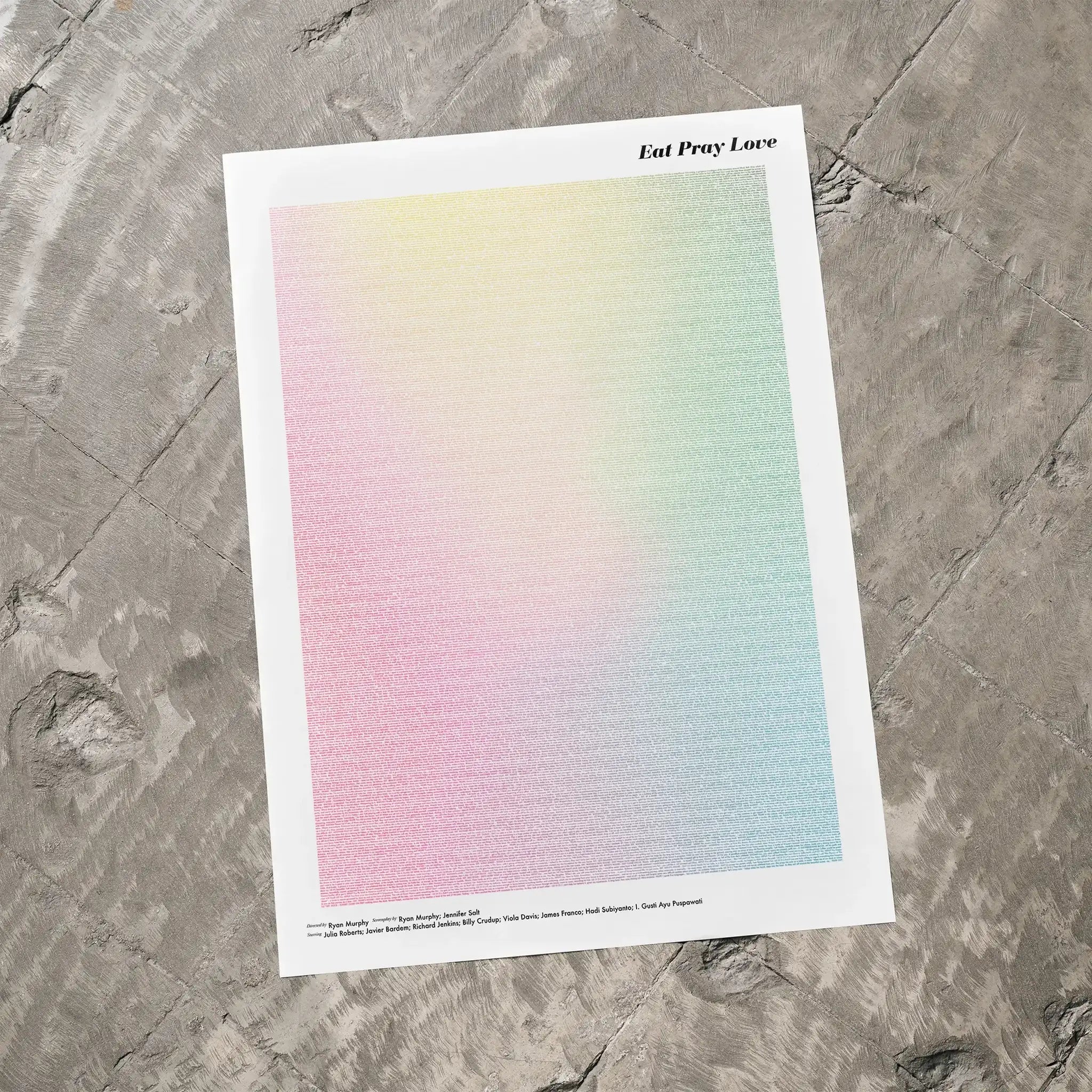 A Eat Pray Love movie script poster laid flat on a textured floor surface.