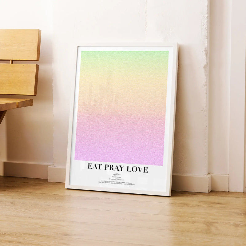 A framed Eat Pray Love movie script poster leaning against a wall in a modern interior.