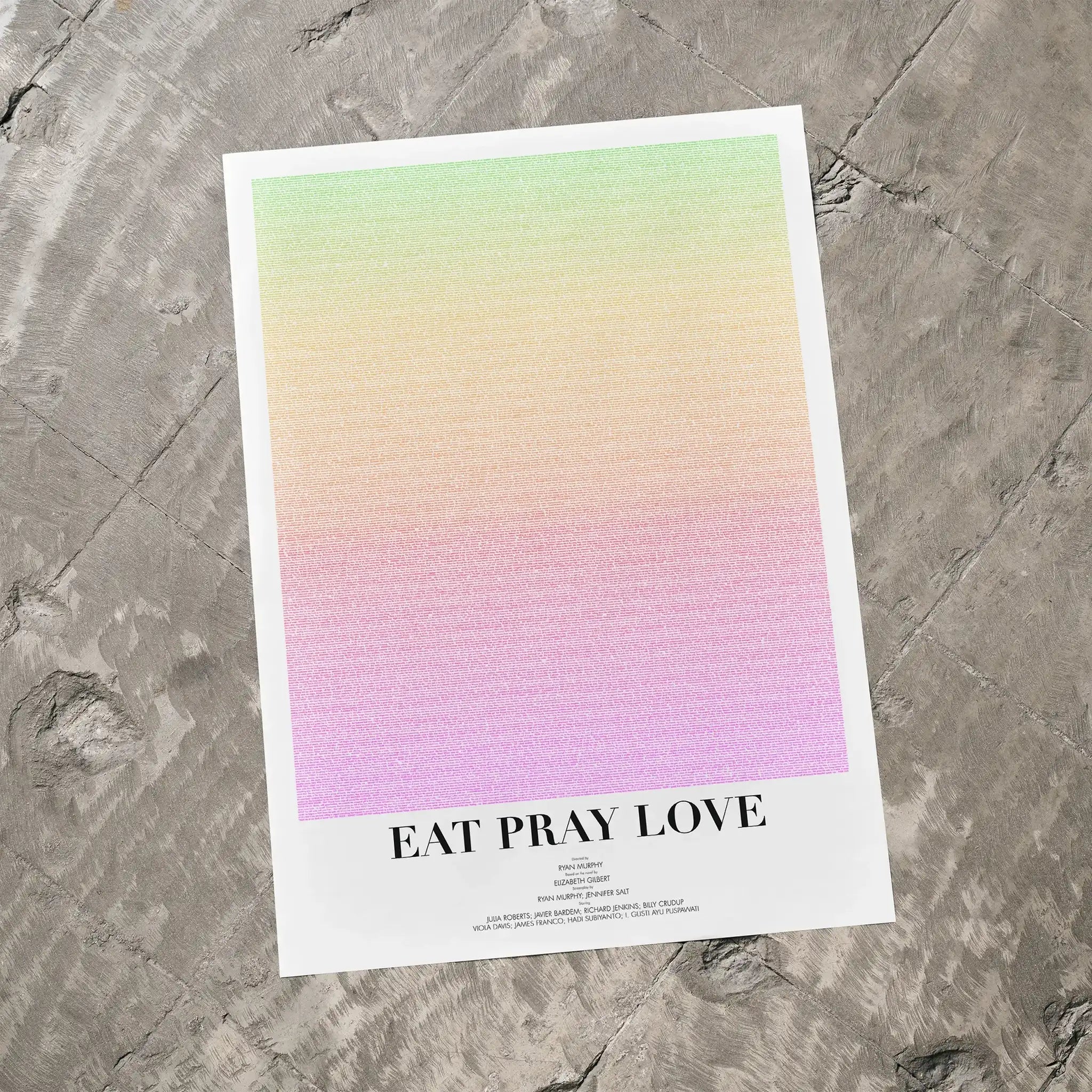 A Eat Pray Love movie script poster laid flat on a textured floor surface.