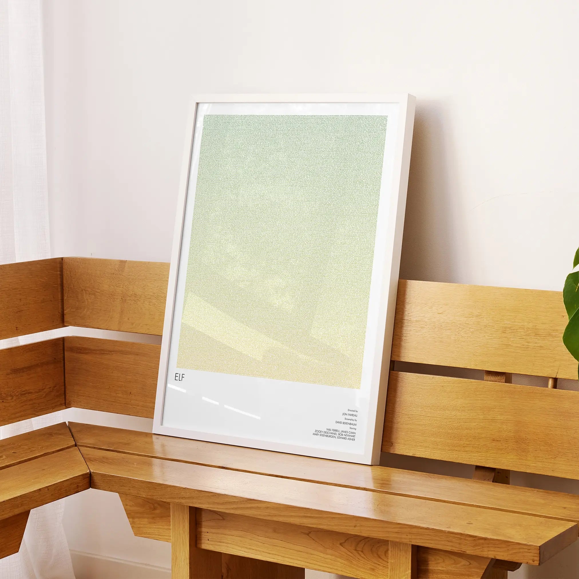 A framed Elf movie script poster displayed on a sideboard in a contemporary space.