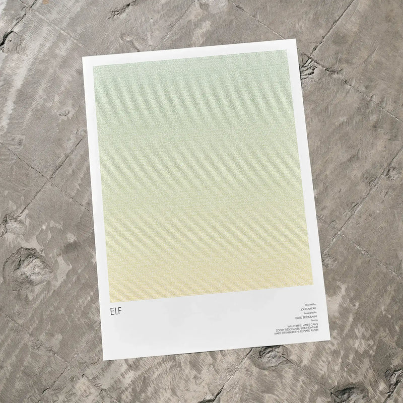A Elf movie script poster laid flat on a textured floor surface.