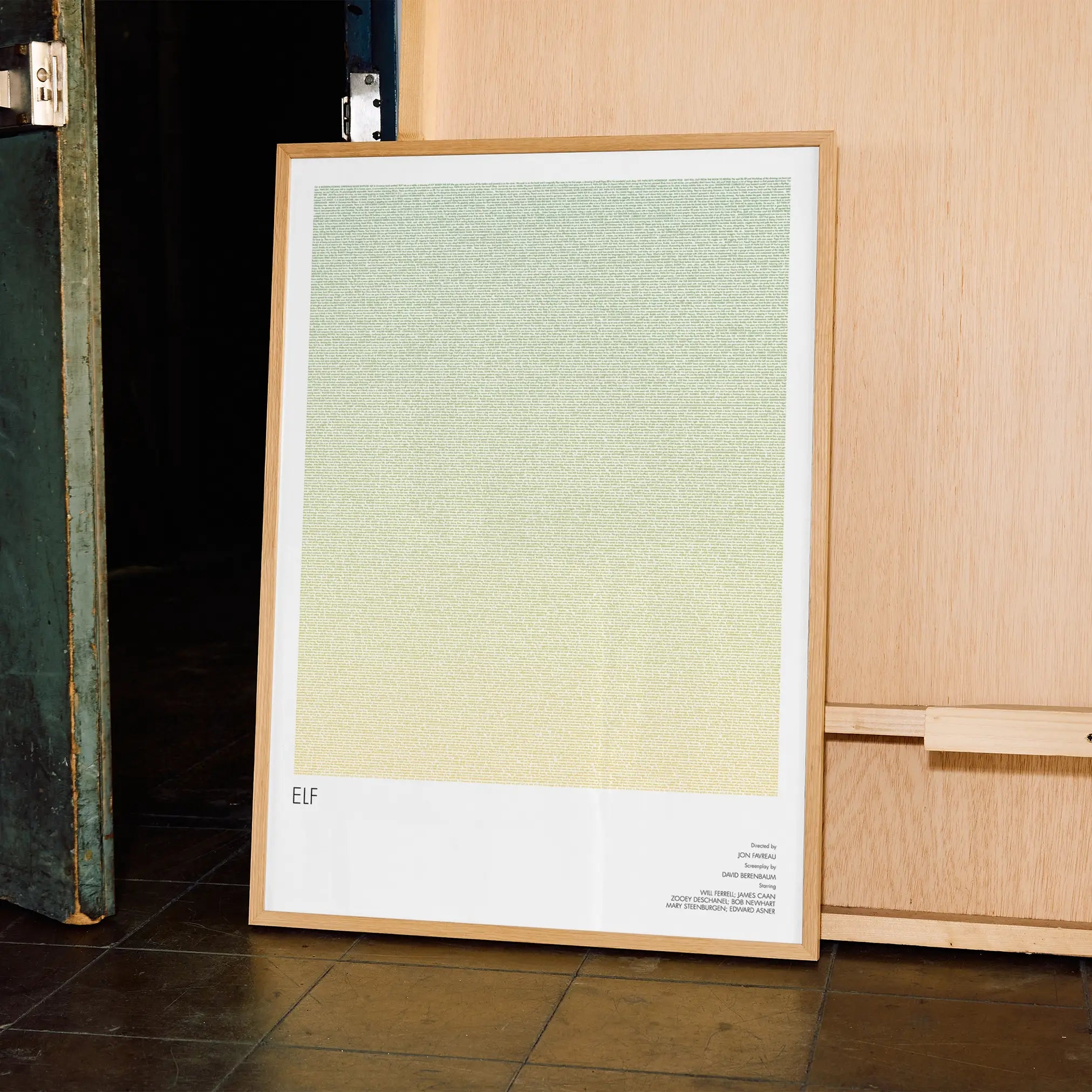 A framed Elf movie script poster displayed in a contemporary interior setting.